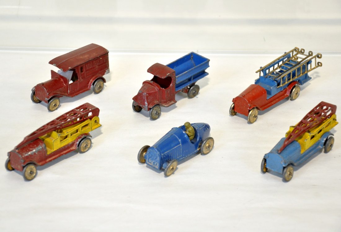 6 Early TootsieToy Vehicles: Includes scarce market truck, missing window struts; racer; fire water tower; fire ladder truck; C-cab Mack coal truck, bed loose; unusual yellow & blue fire water tower. Otherwise all show moderate p
