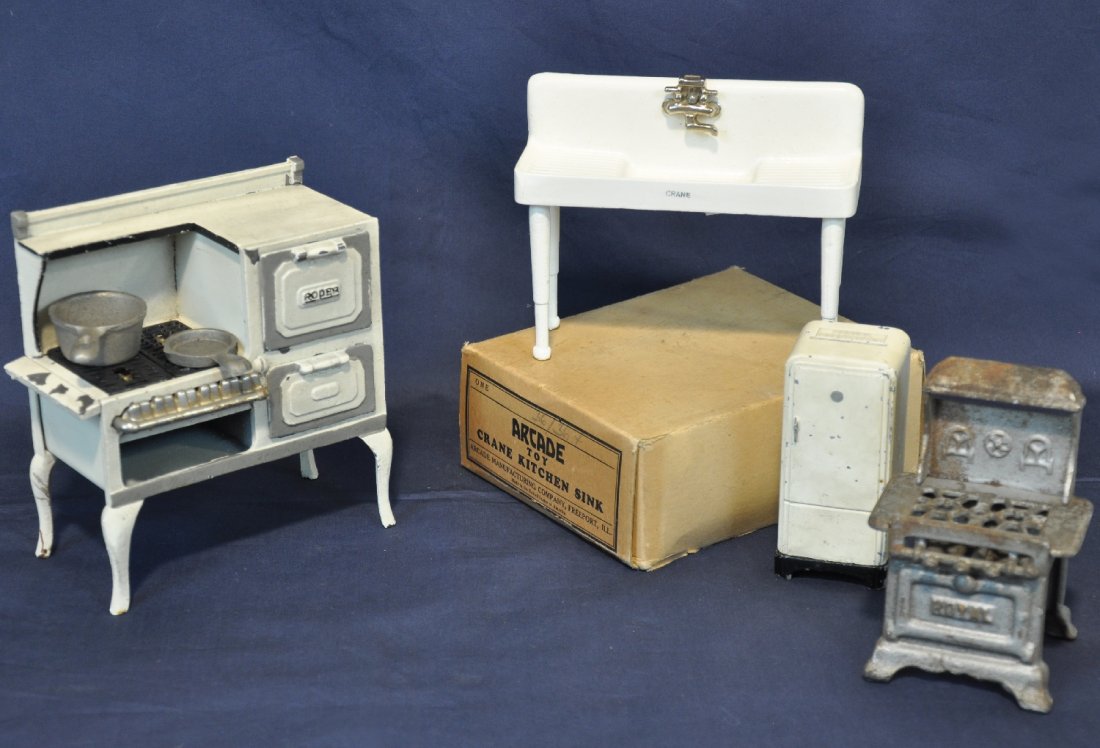 Unusual Arcade Doll House Furniture: Painted cast iron. Includes a 34/364 sink, new in box with insert, C10; stove with grates, pot & pan, C6; small size refrigerator Penney bank; Early silver painted stove. Otherwise showing moderate pl