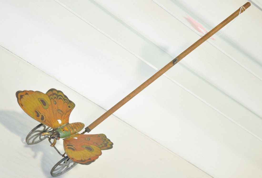 Scarce Gibbs Butterfly Toy: Circa 1920. Paper litho on tin with cast iron wheels with wood stick. 9" wing span with 25" overall length. It shows moderate playwear with nice color, C5+-6