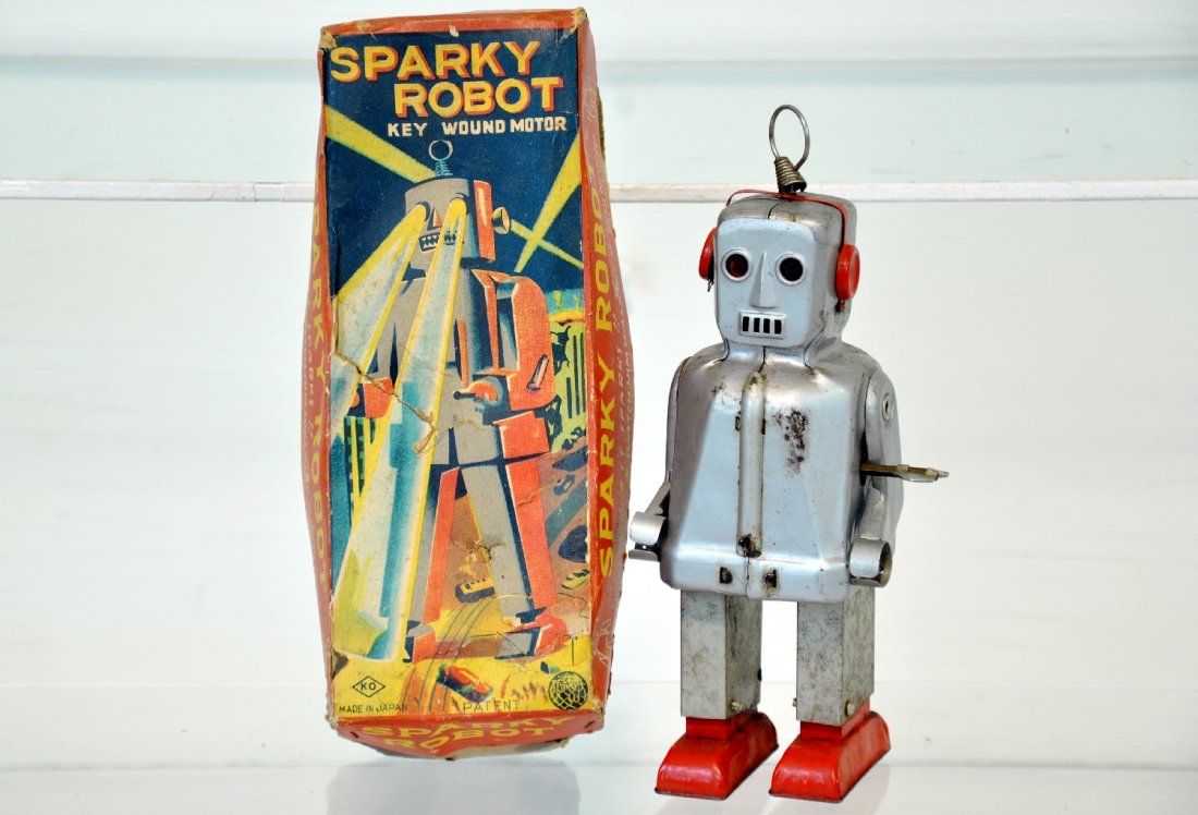 Scarce Boxed Sparky Robot: 7" painted tin, mechanism functional and complete. It has some minor rust spots and comes with its worn original box. It shows moderate playwear, C5-6