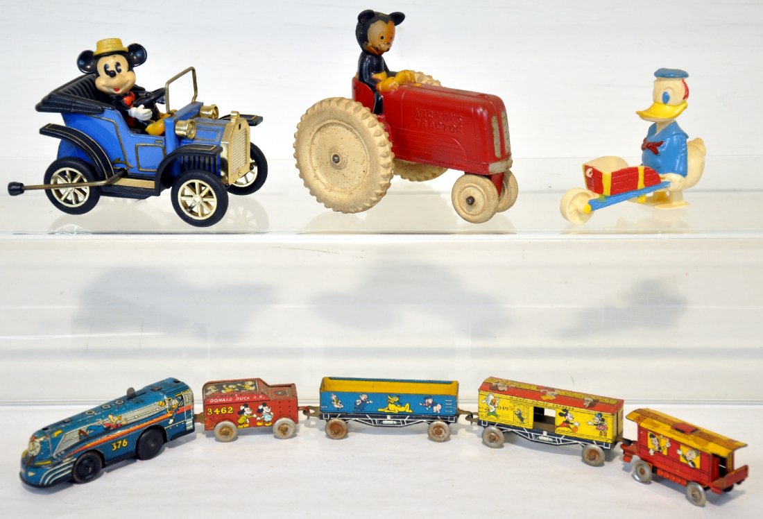 Early Disney Toys Lot: Includes a Marx mechanical train set, functioning; Sun Rubber Mickey Mouse tractor; Donald Duck HP walker; Modern Toy, Japan, plastic lever Mickey Mouse car. All show light playwear, C7-8