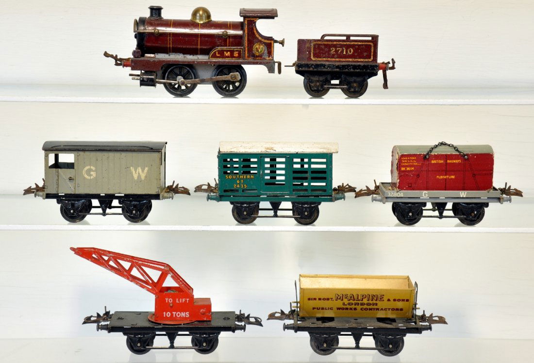 7Pc Hornby Steam Freight Set: O Gauge. Includes an LMS loco, mechanism functions with reverse; 2710 tender; crane car, missing string & line; flat with crate; 2435 stock car; McAlpine tipple car; GW brake van. All show moderate pl