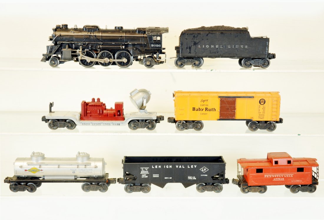 7Pc Lionel 2026 Steam Freight Set: Includes a 2026 loco; 2466W tender, C5+; 2454 BR boxcar; 6520 searchlight car; 2456 hopper; 2465 Sunoco tank car, rubber stamped frame version; 2472 PRR caboose, C6. Otherwise cars show light to moder