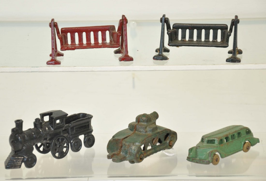 5 Cast Iron Toys: 4 inch carpenter locomotive with chipped roof, 2 Arcade swing benches. Hubley 3 1/2 inch city bus missing one tire, and a scarce Hubley 3 inch tank. Otherwise show moderate playwear C5-6