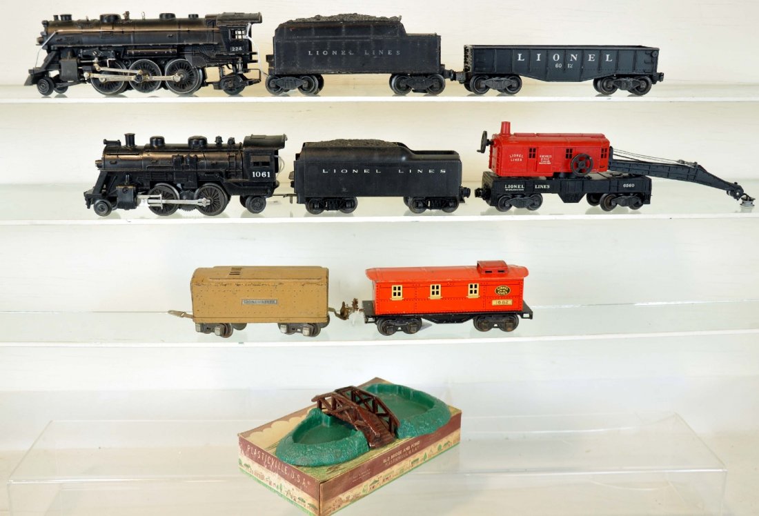 9Pc Toy Train Lot: Includes a Plasticville pond, nice ob, C9; Lionel 224 loco, incorrect motor screw; 2466W tender, shell cracked; 1061 loco, latch support broken; 1060T tender; 6560 crane, boom broken; 2452 gondola; 16