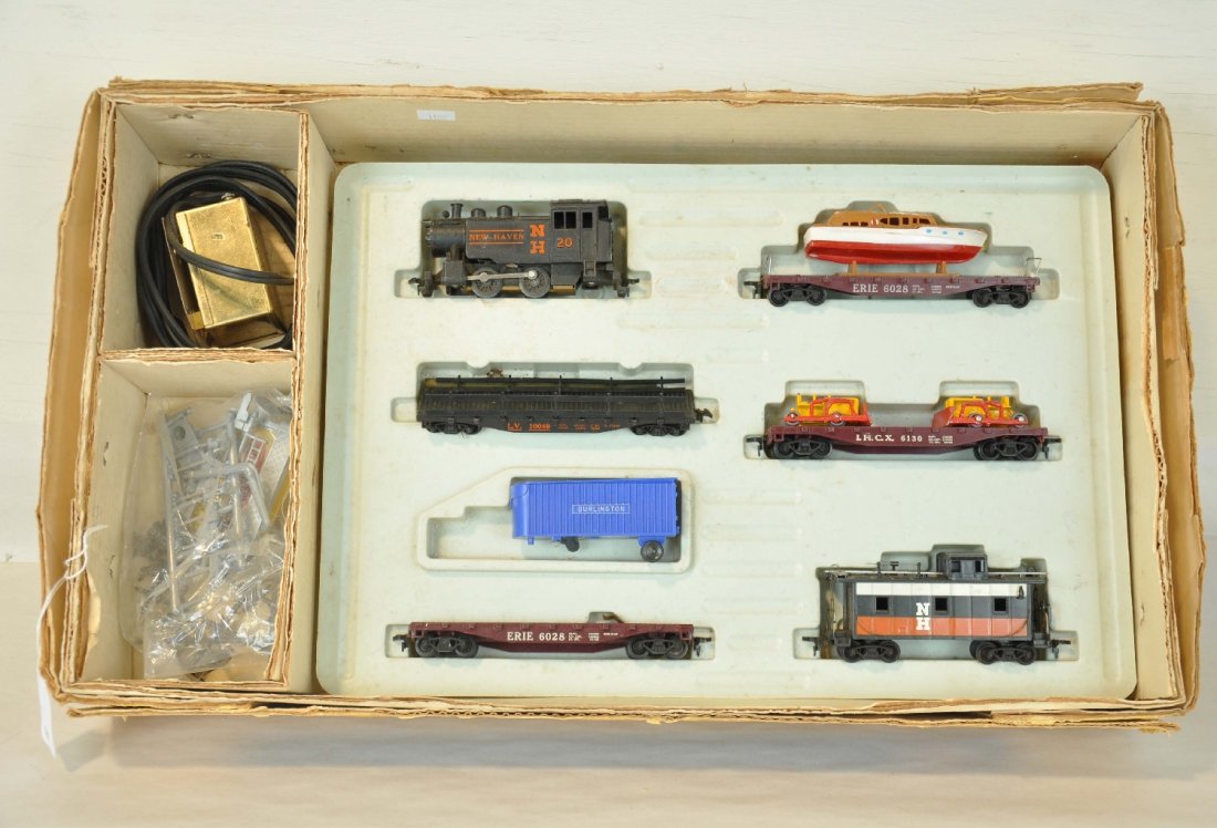 Boxed Marx HO Allstate Set 9830: Includes a NH switcher; flat with yacht; stake flat with 2 logs 1 fence incomplete; flat with 2 tractors, no treads; flat with trailer, missing tractor; NH caboose, track & transformer with 3-pc bridg