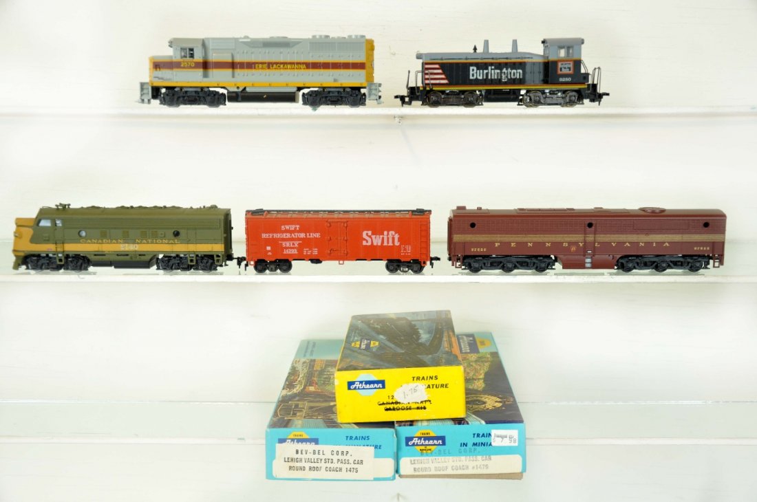 8Pc Boxed Athearn HO Lot: Includes a Erie GP35 diesel, C9; PRR PB1 dummy; Burlington diesel; Custom CN F7 diesel; 2 Bev-Bell LV coach kits and 2 built-up freight cars, 1 apart again. All otherwise show light handling with boxe