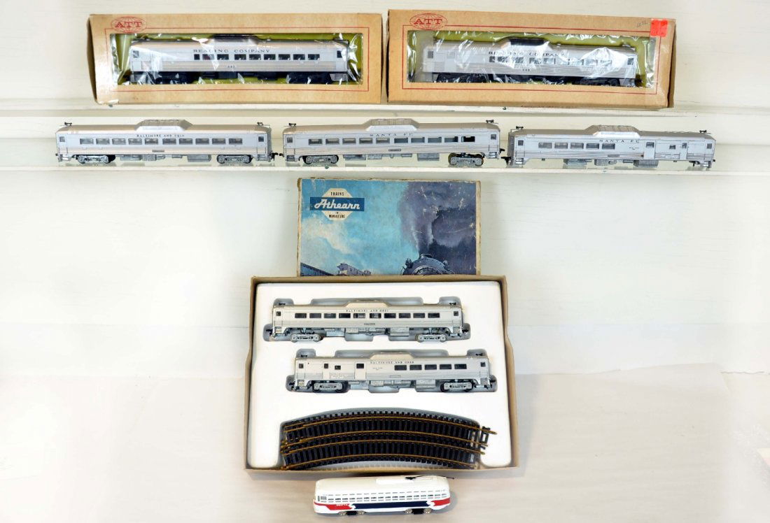 7Pc Assorted HO Trains Lot: Includes a boxed Athearn B&O Budd set with track, faded setbox; additional loose matching trail car; pr SF Budd cars for parts; ATT Reading Budd AA set, obs; Bachmann Septa trolley bus, C7-8