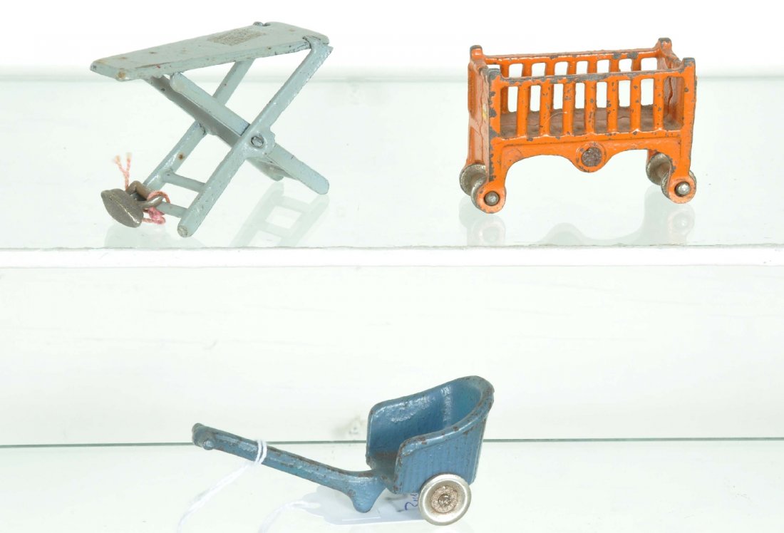 3 Arcade Cast Iron Toys: Includes a 3" ironing board with scarce matching iron; 3" baby's crib; 4" stroller. All are clean and show moderate playwear, C6-7