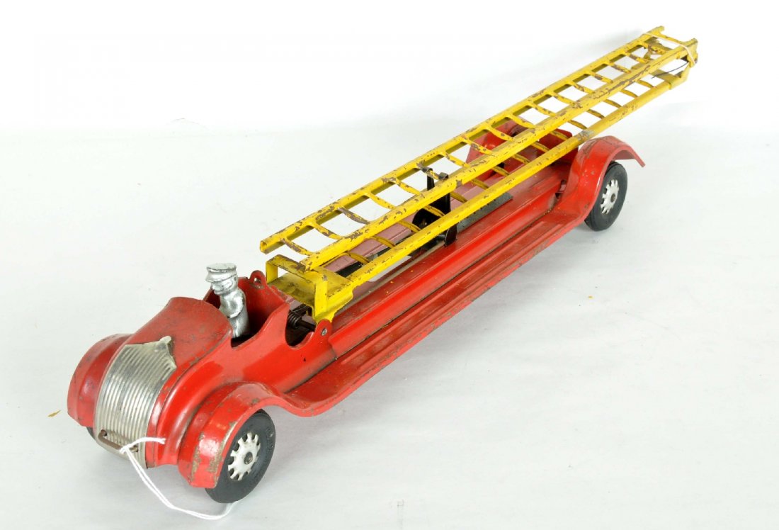 Kingsbury Operating Fire Ladder Truck: Circa 1930s. Painted pressed steel, 23" long with rubber tires. Drive mechanism functions. Bump and go ladder release functions, but main ladder spring is weak and doesn’t hold vertical. It is fairl
