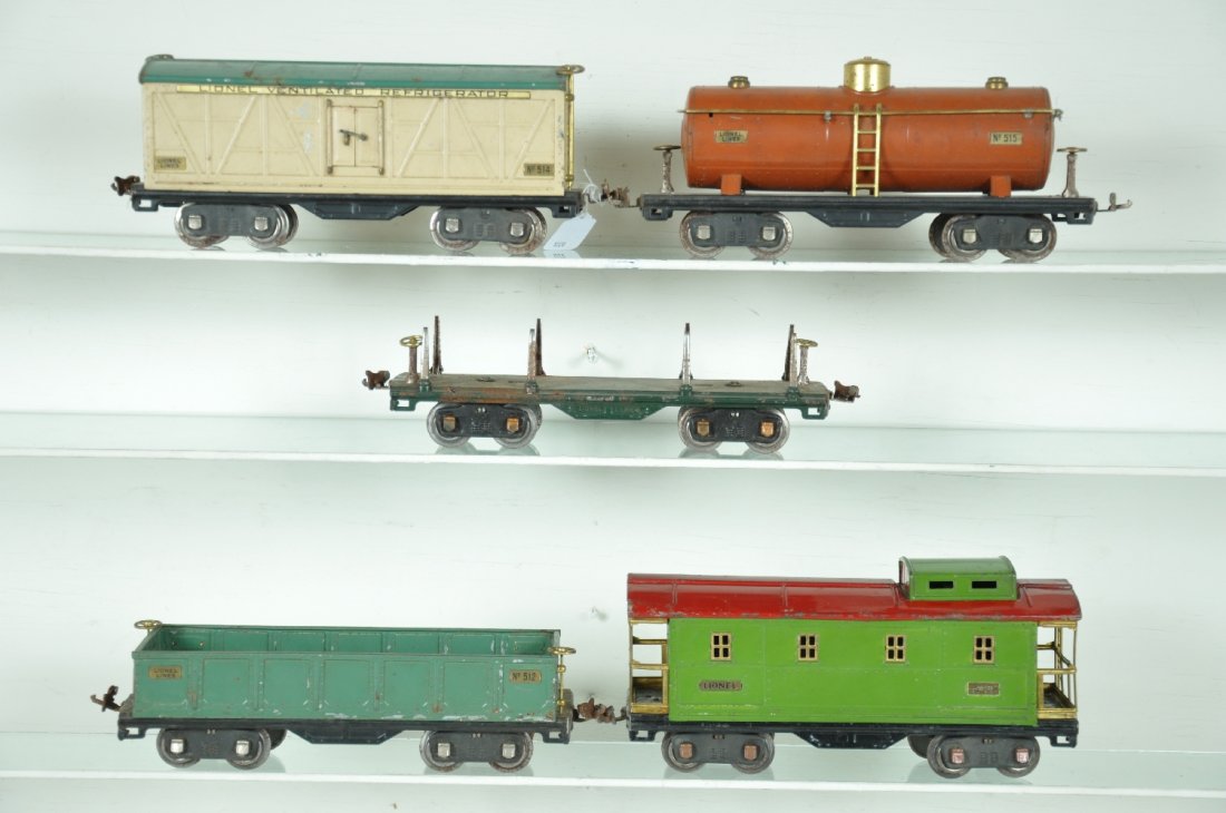 5 Lionel; 500 Series Freight Cars: ST Gauge. Includes a 514(R) reefer; 515 tank car, some loose stanchions; 512 gondola, some edge flaking; 511 lumber, no load; 517 caboose. All show moderate playwear, C5-6
