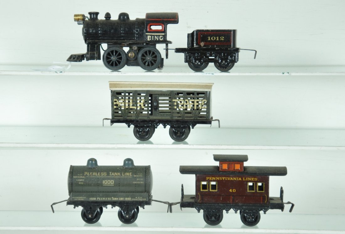 5Pc Bing Steam Freight Set: O ga. 0-4-0 electric steam loco with 1012 tender; Milk Traffic stock car; Peerless tank car; PRR bobber caboose. All need a cleaning, but only show light to moderate playwear, C7