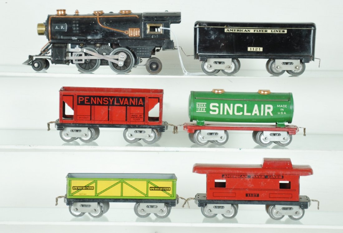 6Pc American Flyer 401 Freight Set: Includes a 401 2-4-0 steam loco, replaced pony wheels; 1121 tender, slight dent; 1128 Sinclair tank; 1123 sand car; 1126 hopper, light spider webbing; 1127 caboose. All could use a dusting, but show l
