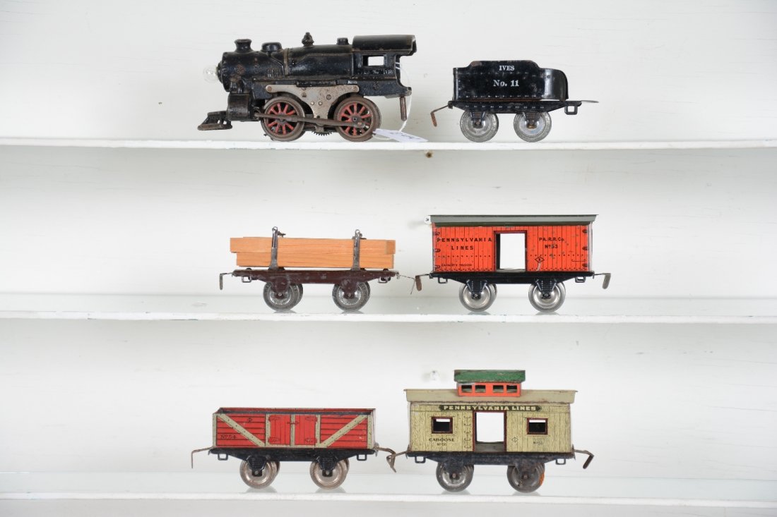 6Pc Ives 1100 Freight Train Set: Includes an 1100 steam loco, Lionel pick-up; 11 tender; 51 lumber car; 53 boxcar, roof restored nicely; 54 gondola; 56 caboose. All show moderate playwear, otherwise C6