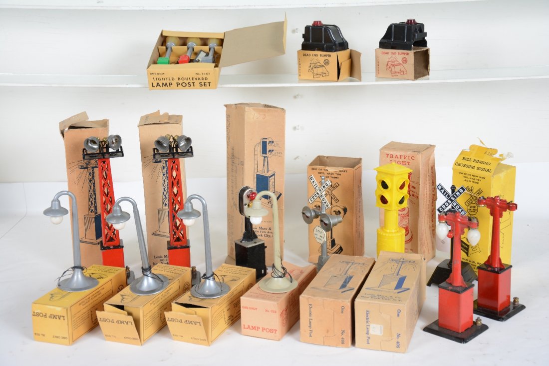 15 Boxed Marx Accessories: Includes 4 #072 lampposts, 3 silver, 1 gray; 2 #0605 bumpers; 073/3 boulevard lamps; 2182 street light, ob rough; 417 bell signs; 2 #416 floodlight towers; 2 #408 twin lights; flasher. All show very l