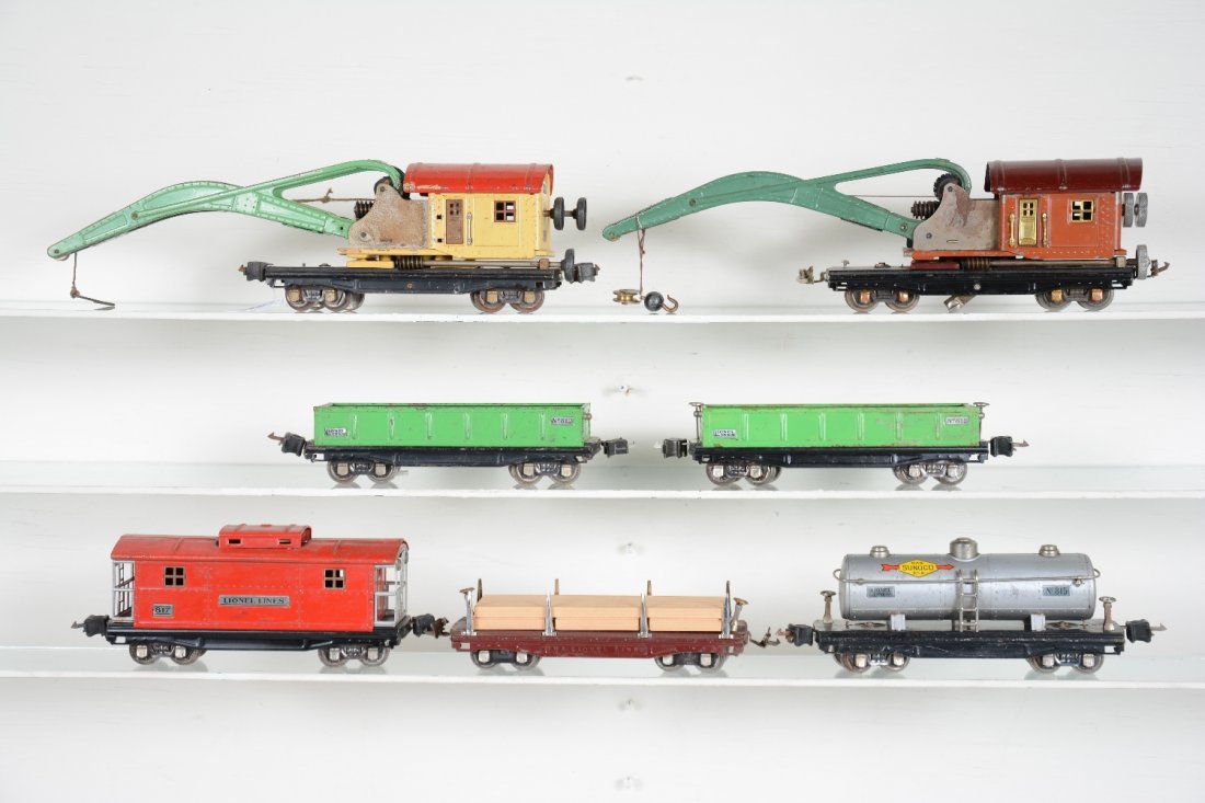 7 Lionel Freight Cars: Includes 2 #810 cranes, 1 missing hook, gears fatigued; early 811 lumber car, replaced stakes & load; 2 #812 gondolas; 815 Sunoco tank car; 817 caboose. All are fairly clean & shiny, but show moderate