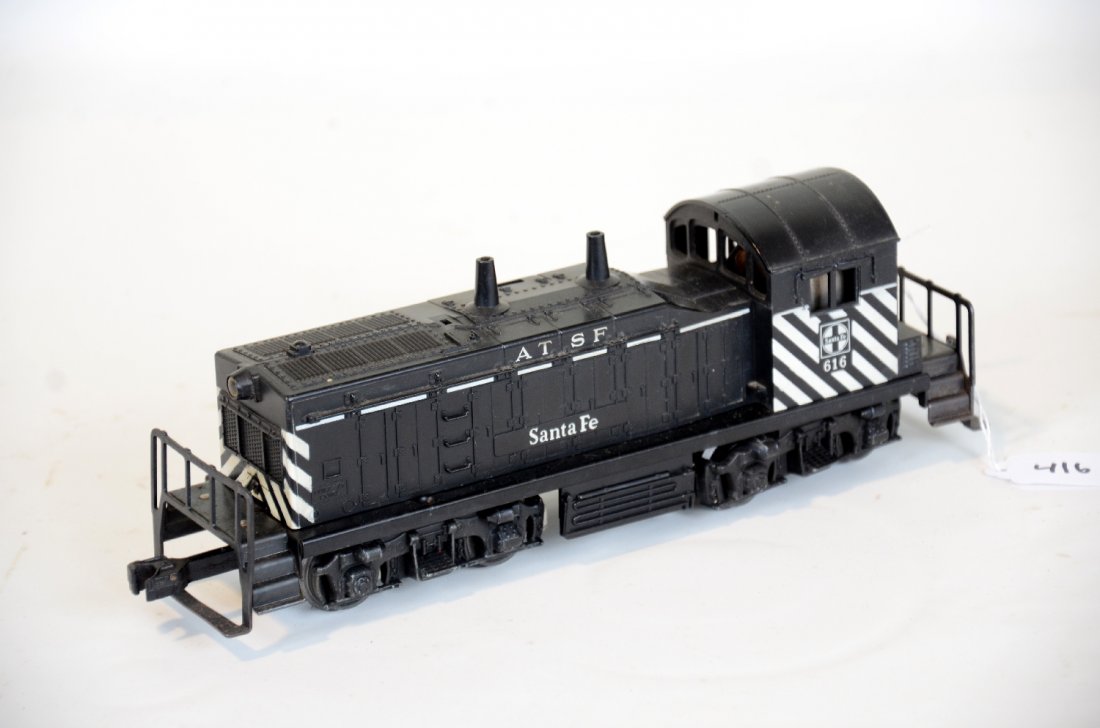 Lionel 616 SF NW2 Diesel: Desirable diesel with safety stripes. It has the usual hairline screw crack and shows moderate playwear with light oxidation spots on frame, C6