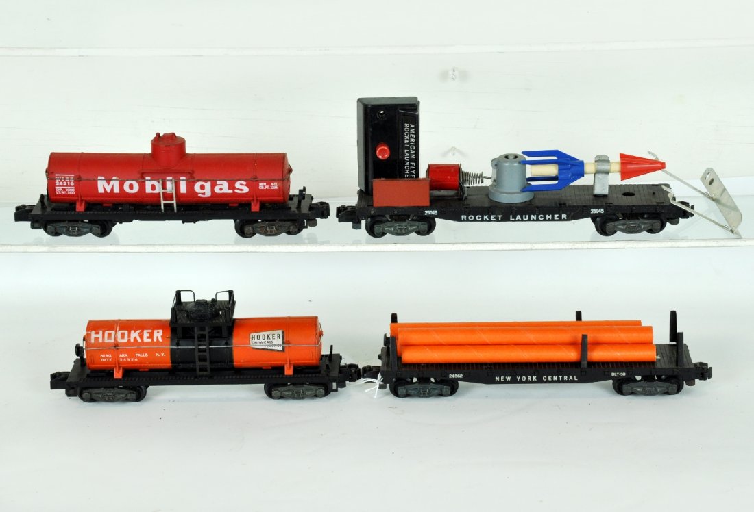 4 Clean American Flyer Freight Cars: S Gauge. Includes a 24045 rocket launcher, complete; 24324 Hooker tank car; 24562 NYC flat with cardboard pipes; 24316 Mobilgas tank car, all have iron trucks, are intact and clean, showing light play