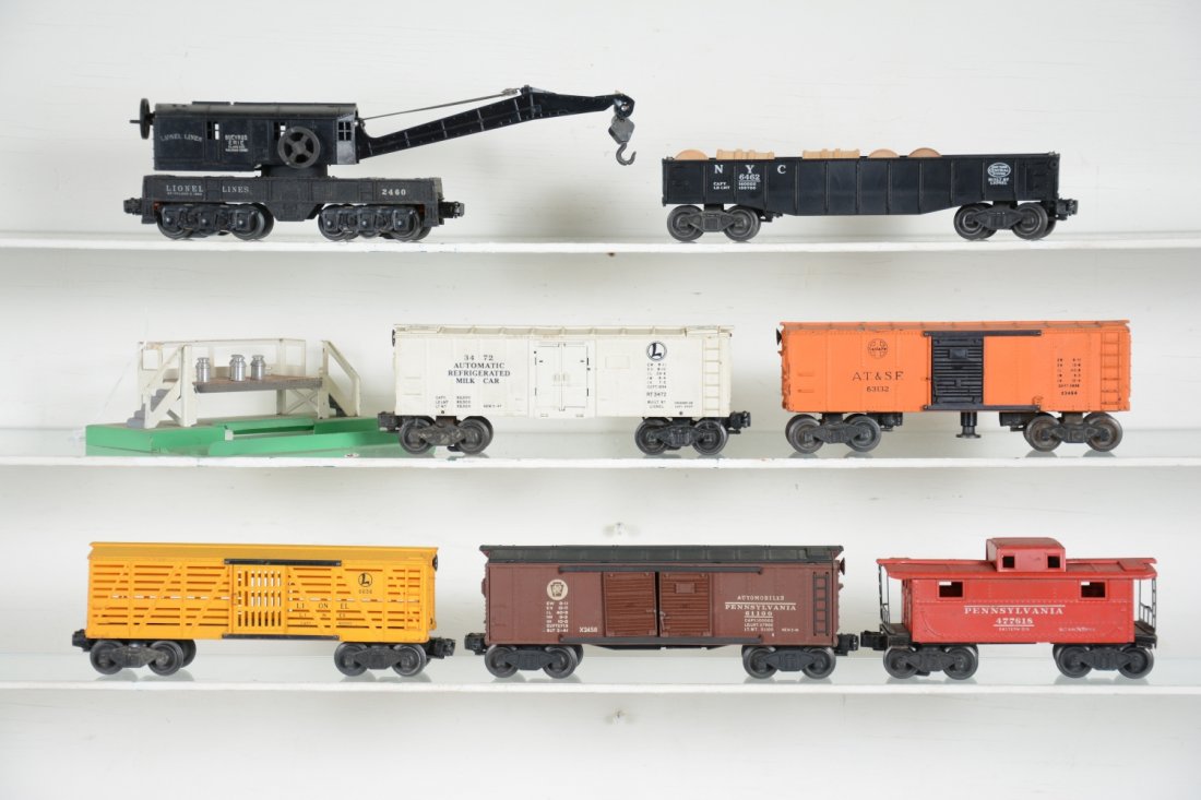 7 Lionel Freight Cars: Includes a 2460 crane with later boom; 3472 milk car with platform and 4 cans; 2472 PRR caboose; 2458 PRR boxcar, roof painted; 3464 SF operating boxcar; 6462 gondola with drums; 6656 stock car. All a