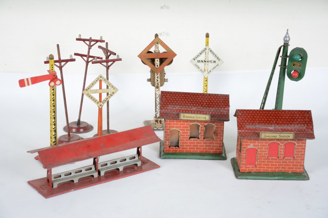 Pre War Accessory Group: Includes 2 Chein stations; Hafner station platform, semaphore & warning sign; American Flyer block signal with replaced finial; 3 telegraph poles & warning sign; Lionel 69 ringer. Grade range is C3-7,