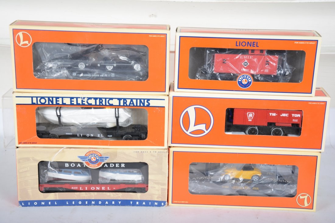 Lionel Freight Cars: Includes 17537 flat with Buicks; 19428 boat-loader; 16661 flat with operating boat; 26593 Erie caboose; 17522 flat with Prowler; 18427 55 Tie-Jector. All appear new in boxes, C9-10