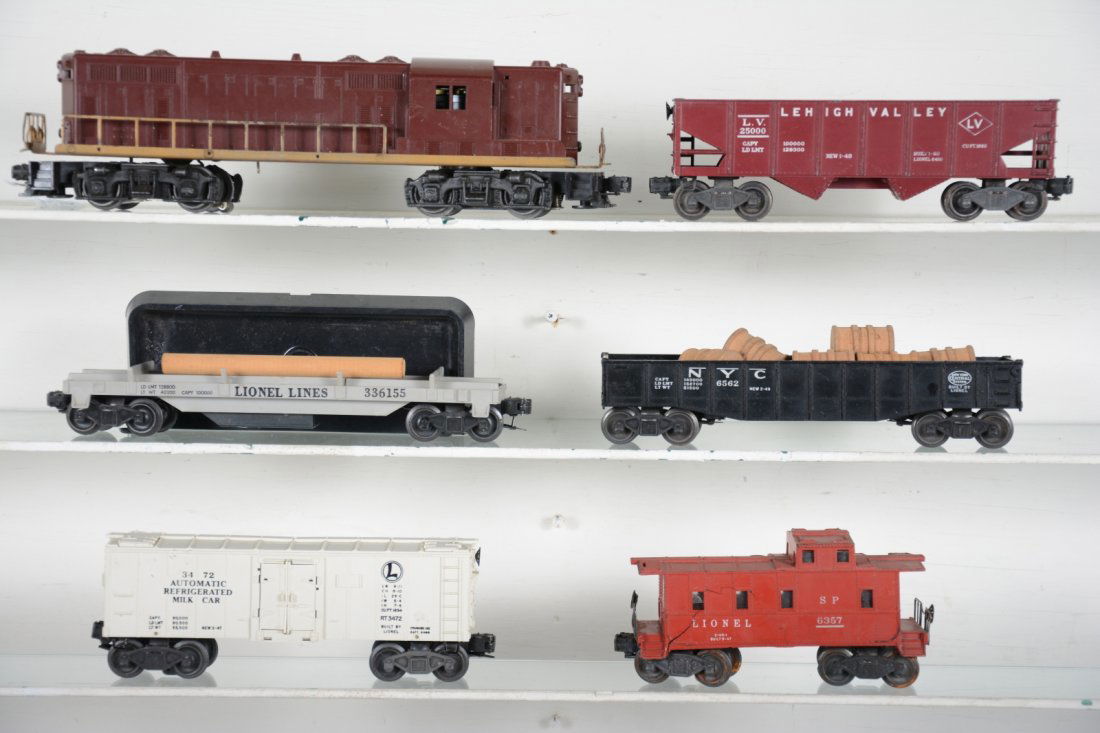 Lionel 2028 Diesel Freight Set: Includes a 2028 PRR GP7 diesel, lettering 0%; 6456 hopper; 361 log dump with bin; 6462 gondola with drums; 3472 milk car, no platform; 6357 caboose, shell cracked. All show moderate playwear, C6ish