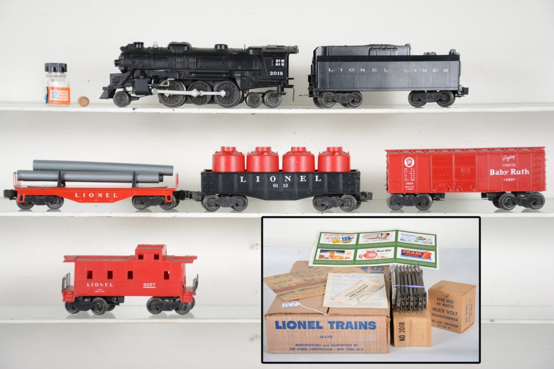 Boxed Lionel Set 1547S: Circa 1957. Includes a 2037 loco with SP pellets and tamper; 6026T tender; 6121 pipe flat; 6112-1 gondola with canisters; 6014 boxcar; 6257 red caboose. Includes loco box, track, transformer and perip