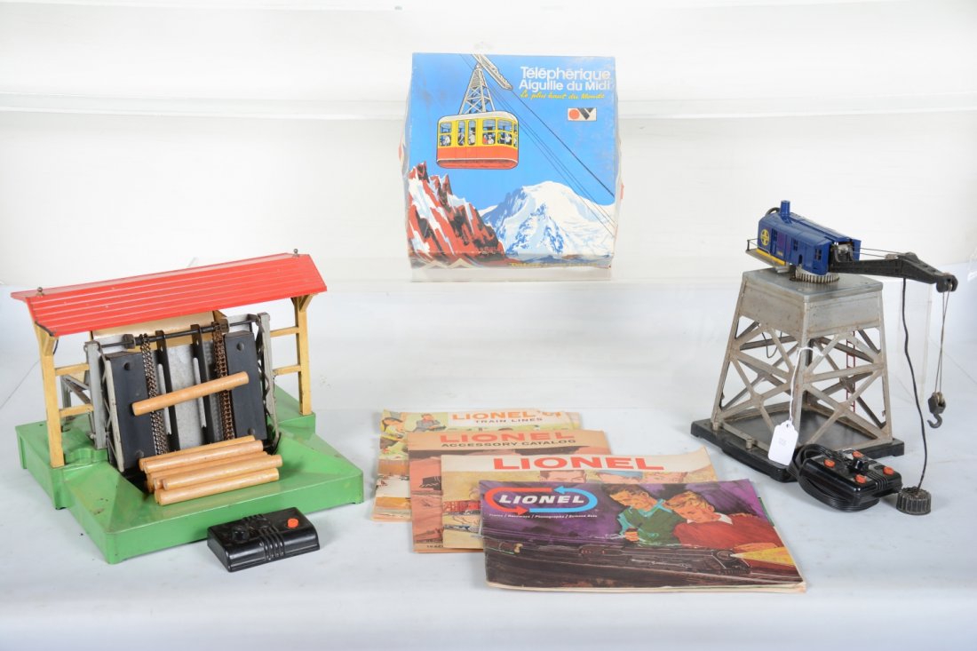Accessory Lot: Includes a Lionel 182 magnetic crane with modern cab; 164 lumber loader with controller, roof has a chip out of corner, repro logs; boxed French cable car set; 3 late Lionel catalogs, good readers as