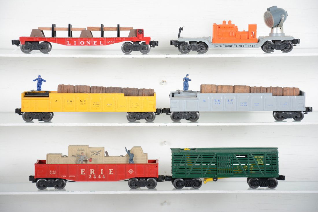 6 Lionel Freight Cars: Includes a scarce 3562-50 yellow painted barrel car; 3562-25 barrel car; 6462 lumber car, replaced load; 3620 searchlight car, replaced generator; 3444 cop & Hobo car; 3376 Giraffe car, broken antlers