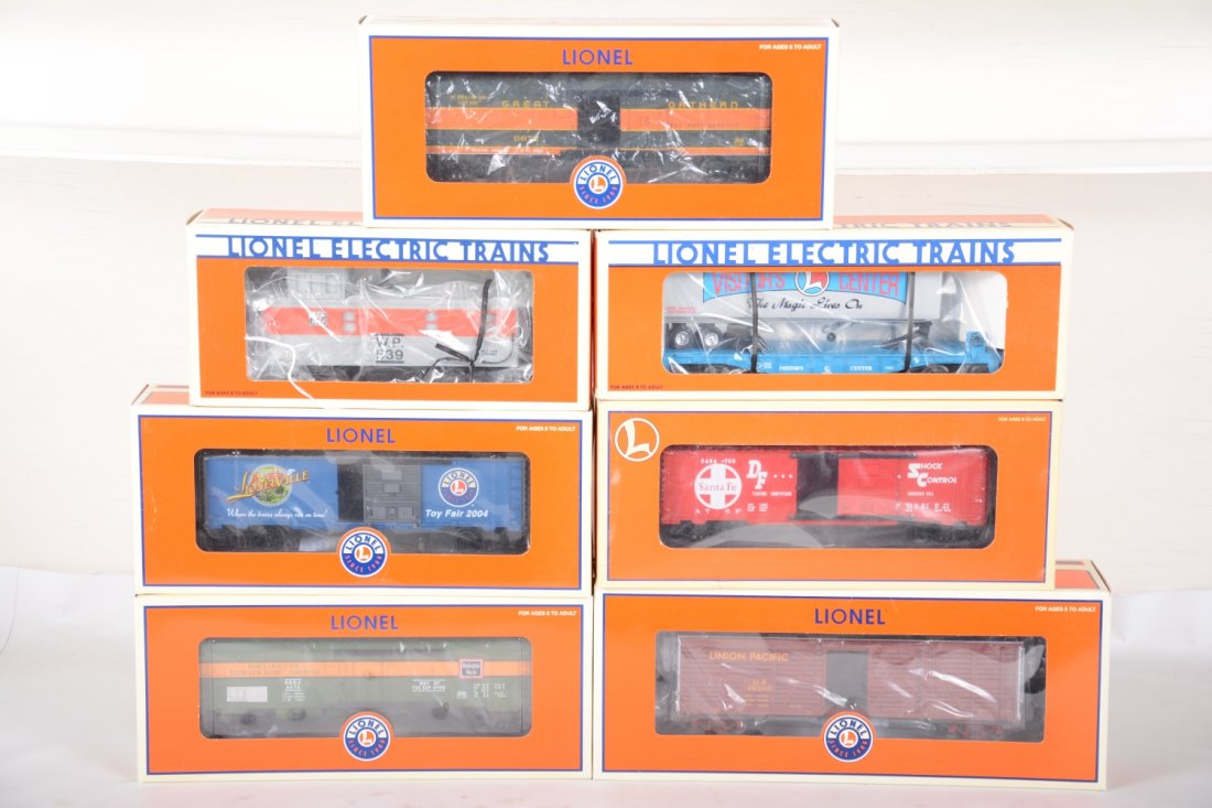 Lionel Freight Cars: Includes 29919 2004 Toy Fair boxcar; 29291 SF boxcar; 16539WP smoke caboose; 19948 flat with trailers; 19565 Burlington reefer; 17709 UP stock car; 19568 GN reefer. All are new in boxes, C10