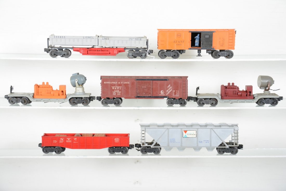 7 Lionel Freight Cars: Includes a 3359 double dump car; 6462-125 gondola with replaced barrels; 6464-50 M&StL boxcar, type I; 3620 searchlight; 3464 SF operating box car; 6346 Alcoa covered hopper; 6520 searchlight, oxidati