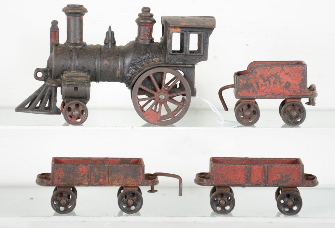 Early Carpenter Cast Iron Floor Train: Patent date 1882. Includes a 7.5" stork leg steam loco, cab has very old repair; tender with 2 gondolas. All show age appropriate 132 year old paint wear, but nice to have the whole set together for a
