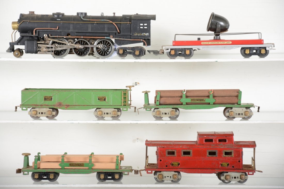 American Flyer Pre War O Group: Includes a 1680 Hudson loco, dusty with worn cab decals, clean rods and motor turns freely; 2 #3206 lumber cars; 3207 sand car; 417 floodlight car, 1 broken coupler, holes in frame end; 3211 caboose, 
