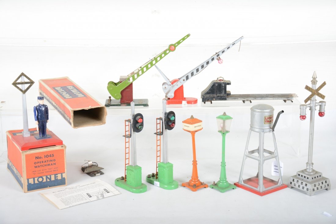 Lionel Pre War Accessories: Includes a boxed 1045 flagman with contactor & instructions; boxed 152 crossing gate; 89 water tank; 25 bumper; 77 crossing gate; 56 boulevard lamp, 45n green; 57 Broadway & Main street lamp; 2 #153 b