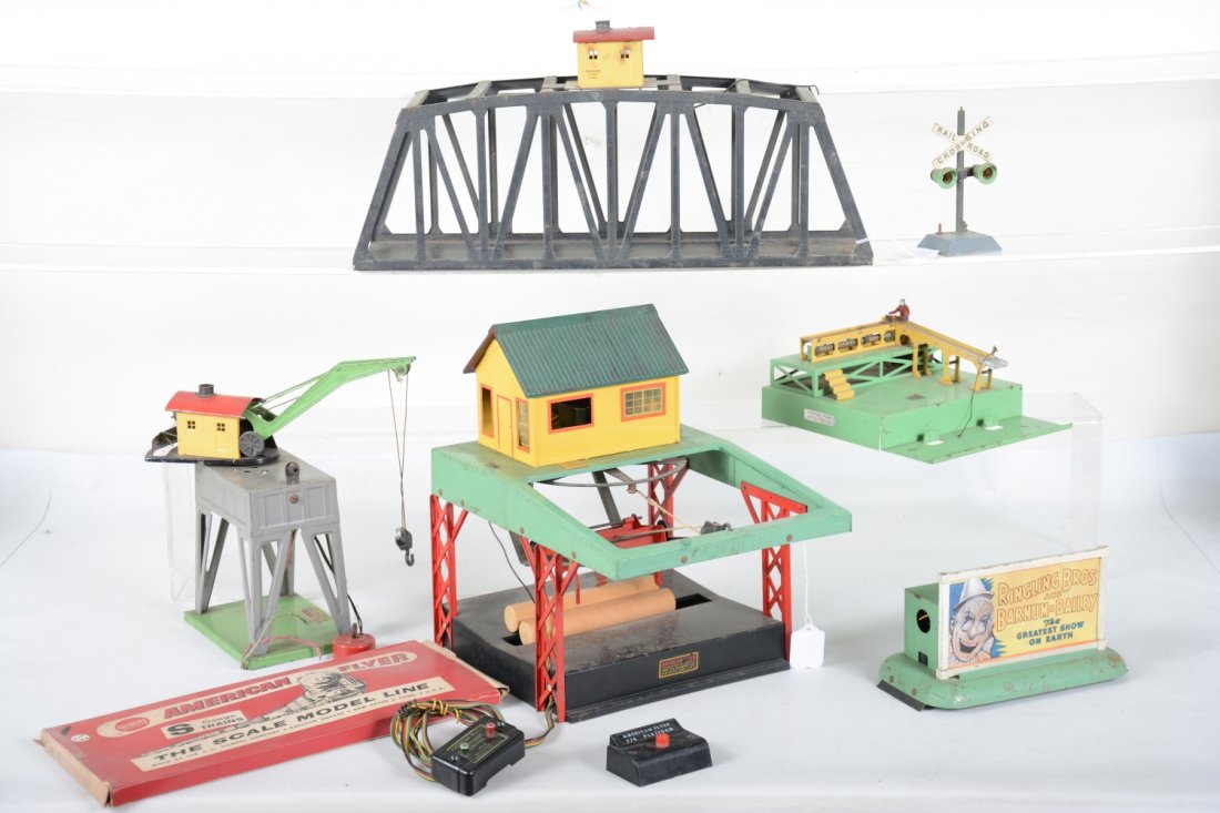American Flyer Accessory Lot: S Gauge. Includes a boxed 26520 remote switch; 571 trestle bridge; 751 log loader with controller, roof repainted; 577 whistling billboard with controller; 771 loading platform, no load, with controll