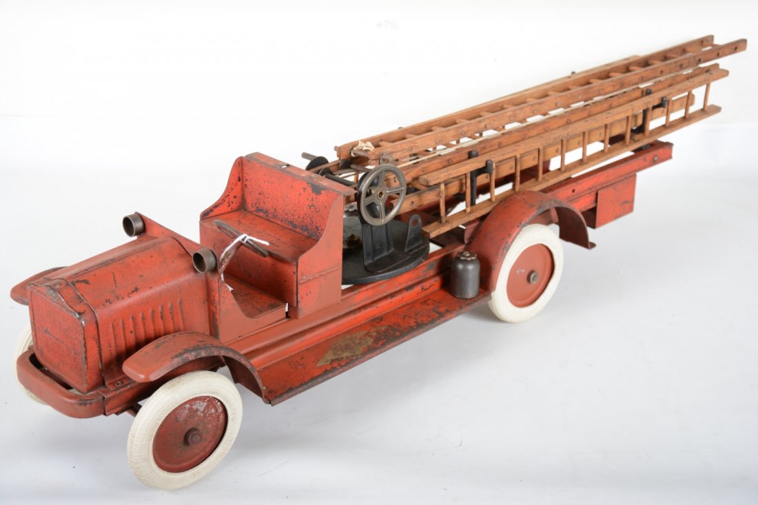 Scarce Kelmet Big Boy Fire Ladder Truck: Painted pressed steel with rubber tires and original wood ladders, 35" long. It has cast iron trim and steel housing. The decals show wear, but are readable. Over-all it shows moderate playwear, C5+