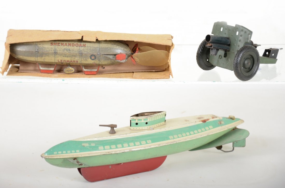 3 Military Toys: Includes a Lehmann Shenandoah Zeppelin, some plating worn but mechanism functions with box bottom. 13" Wolverine submarine, not working, propeller shaft loose; German gun trailer. All show moderate pl