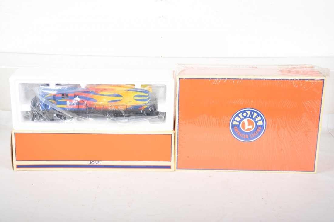 Lionel 18575 & 21774 Dragster Transport Set: Great concept with a flame painted GP-9 diesel, Command equipped with TowerCom; & RailSounds with matching 3 car set. All new in boxes with shippers, C9+-10