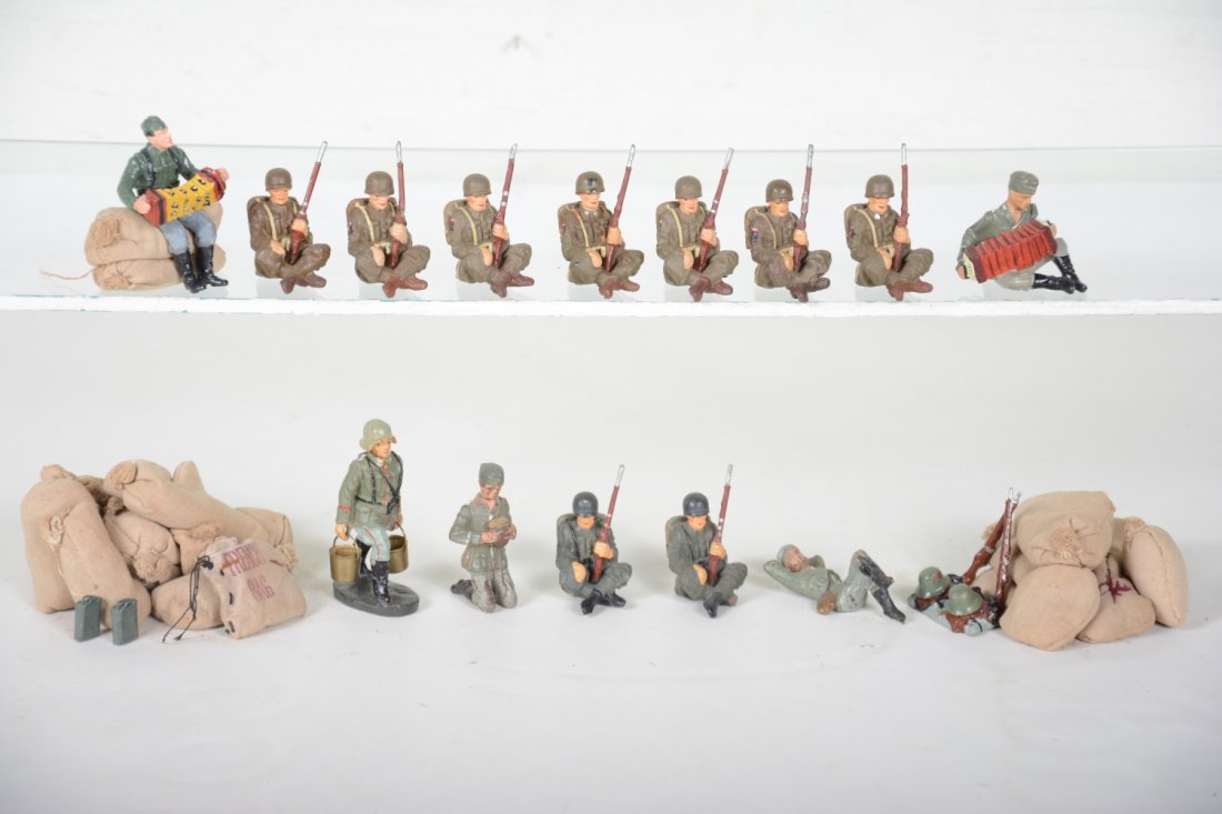 Nice Group German Composition Soldiers At Rest: Includes a Lineol concertina player on ground; unmarked concertina player sitting; 9 soldiers resting on ground with packs; 1 lying on back(C7); soldier carrying pails; gear & gun pile plus several tr