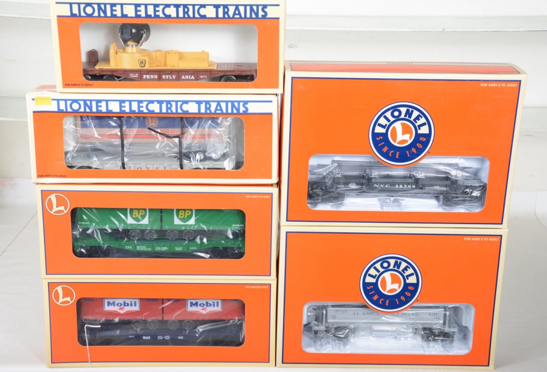 Lionel Freight Cars: Includes 19471 flat with Mobile trailers; 16924 trailer flat, box worn; 16711 PRR searchlight; 26001 BP flat with trailers; 36794 NYC log dump car; 36765 Alaska coal dump car. Rest appear new in boxes