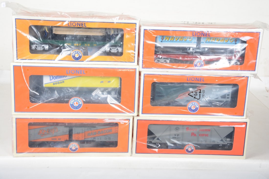6 Lionel Freight Cars: Includes 26335 flat with Domino trailer; 37025 Moe & Joe lumber unloading car; 19577 Krey's reefer; 26624 flat with Navajo trailers; 26416 WP heritage boxcar; 15067 SP hopper. These are old store stoc