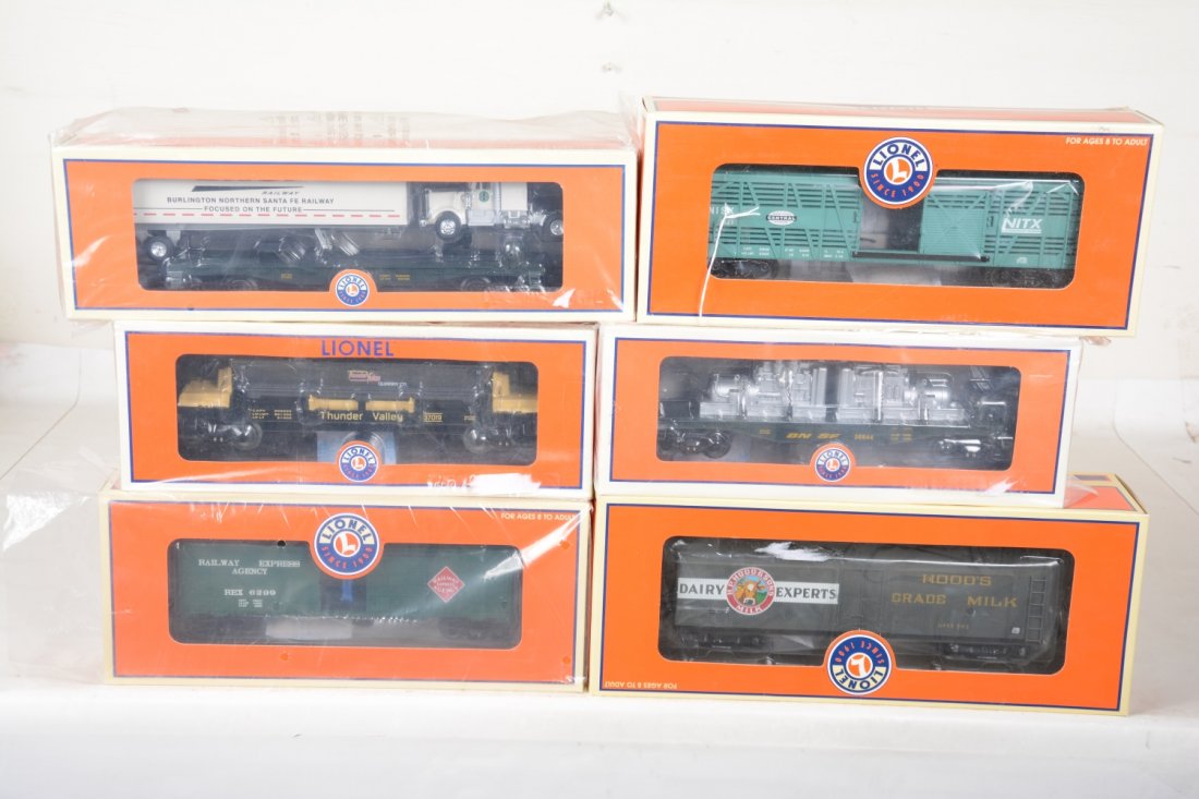 6 Lionel Freight Cars: Includes 26795 NYC stock car with Cattle Sounds; 37019 coal dump car; 17350 Hood's milk; 26792 REA operating boxcar; 26644 BNSF generator car; 26645 BNSF flat with tractor trailer. These are old store
