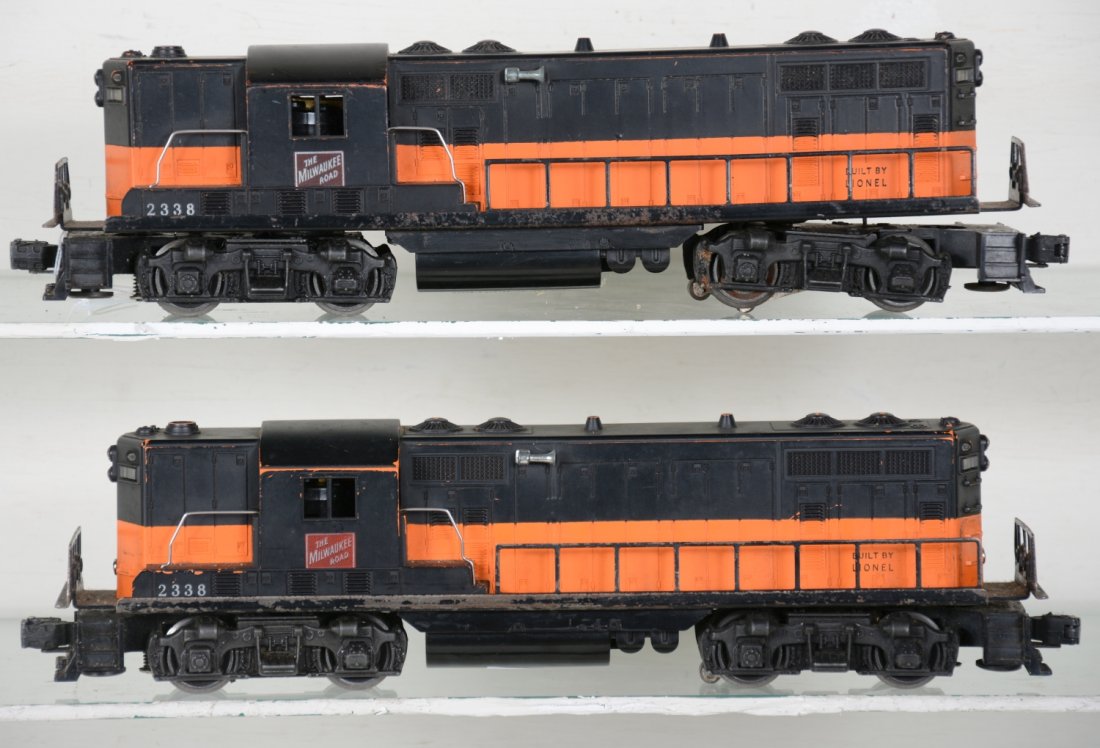 2 Lionel 2338 MR GP7 Diesels: Both are black & orange painted on orange molds. One has light battery corrosion on frame. They show moderate playwear, C5+-6