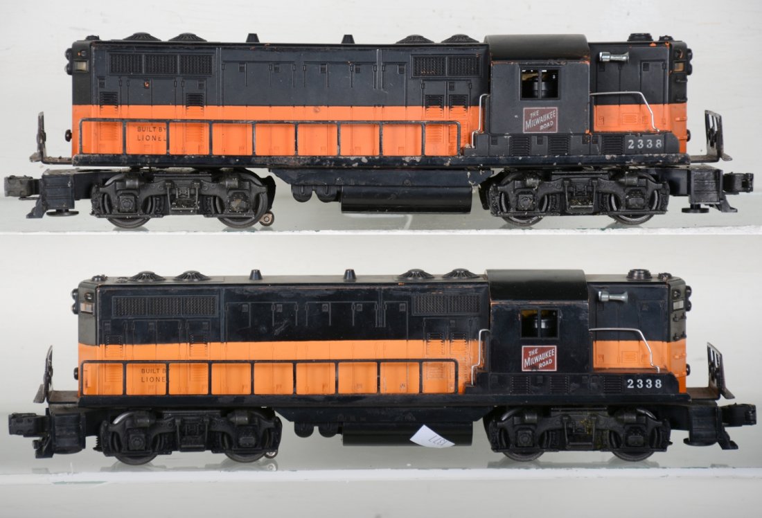 2 Lionel 2338 MR GP7 Diesels: Both are black & orange painted on orange molds. They both have light battery corrosion on frames, 1 has had an added electronic horn with perforations in battery box. They show moderate playwear, C5+