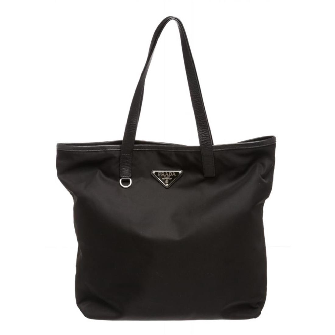 Prada Black Nylon Leather Long Tote Shoulder Bag: Overall push button closure. Interior is Nylon lined. Contains one side zipper pocket and one sideip pocket. Exterior is Nylon with Leather trim. Prada Metal Logo and attached D Ring. Item is pre-owne