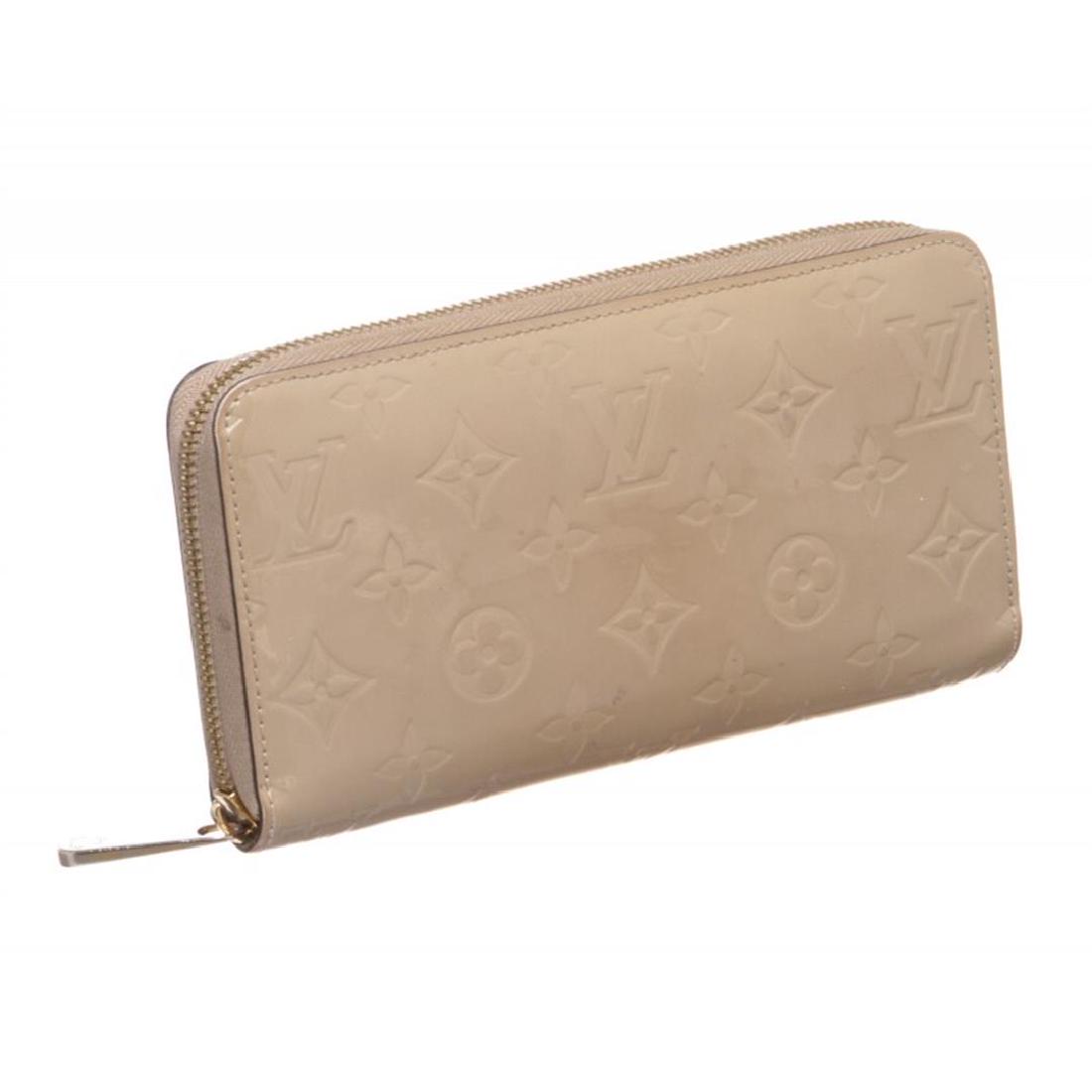 Louis Vuitton Beige Vernis Monogram Zippy Wallet: Monogram Vernis leather Louis Vuitton Zippy wallet with brass hardware, tonal leather lining, four interior compartments; one with zip closure, three bill compartments, eight card slots and zip-around