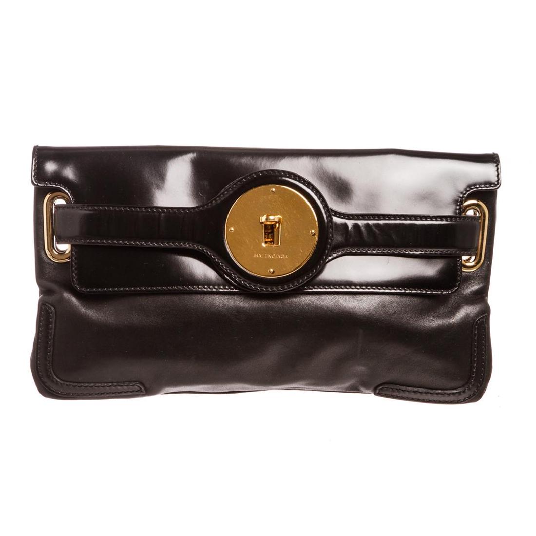 Balenciaga Black Lambskin Leather Clutch Handbag: Crafted out of black lambskin leather, patent leather trim, and gold tone hardware. Inner black fabric lining, dual pocket compartments, and one side slip pocket. Item is pre-owned. Item Dimensions: 1