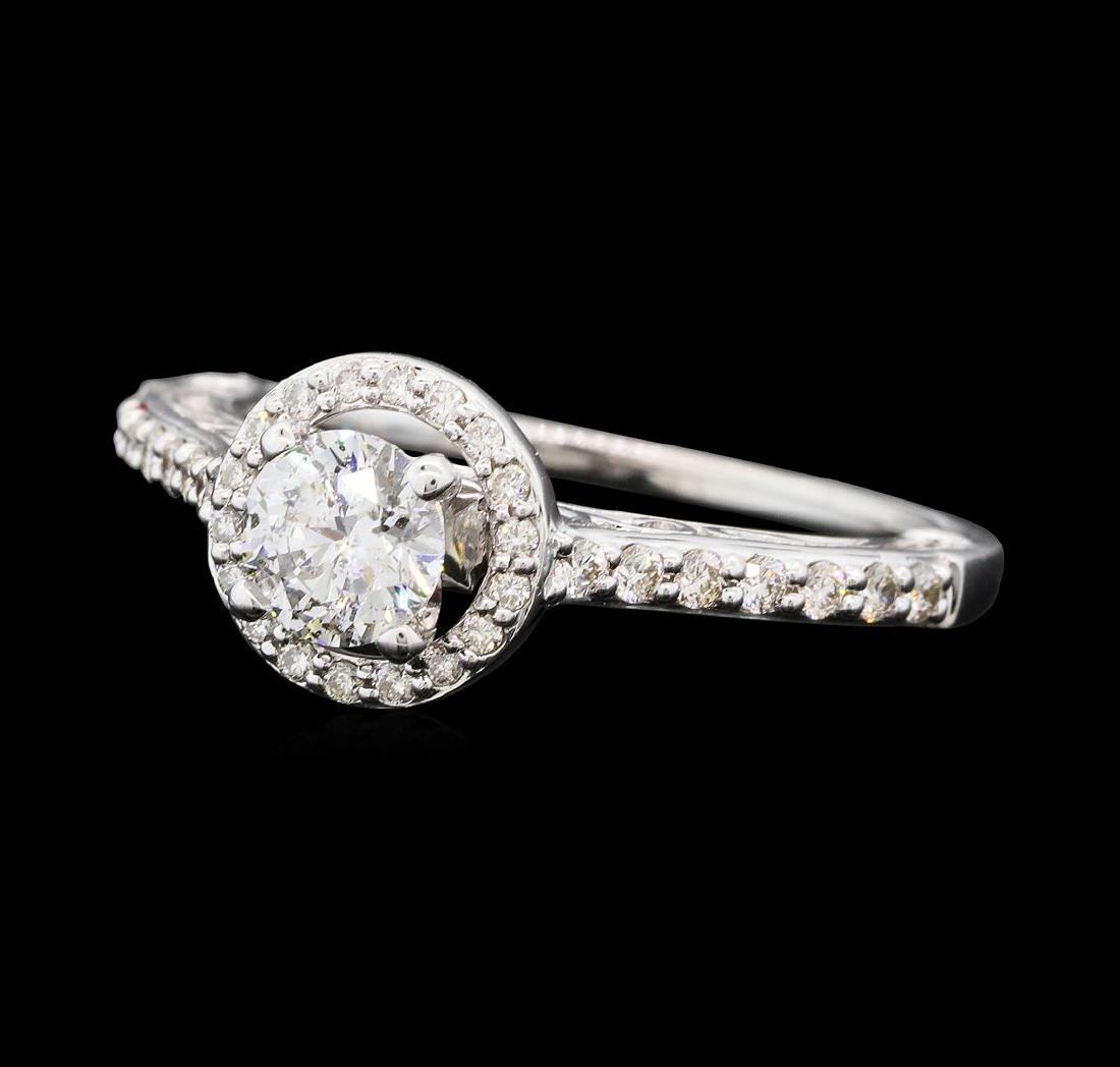 0.79 ctw Diamond Ring - 14KT White Gold: One electronically tested 14KT white gold lady's cast wedding ring with a cathedral shank with a halo with a bright polish finish. The featured lady's ring has a shank measuring 1.25 millimeters wide.