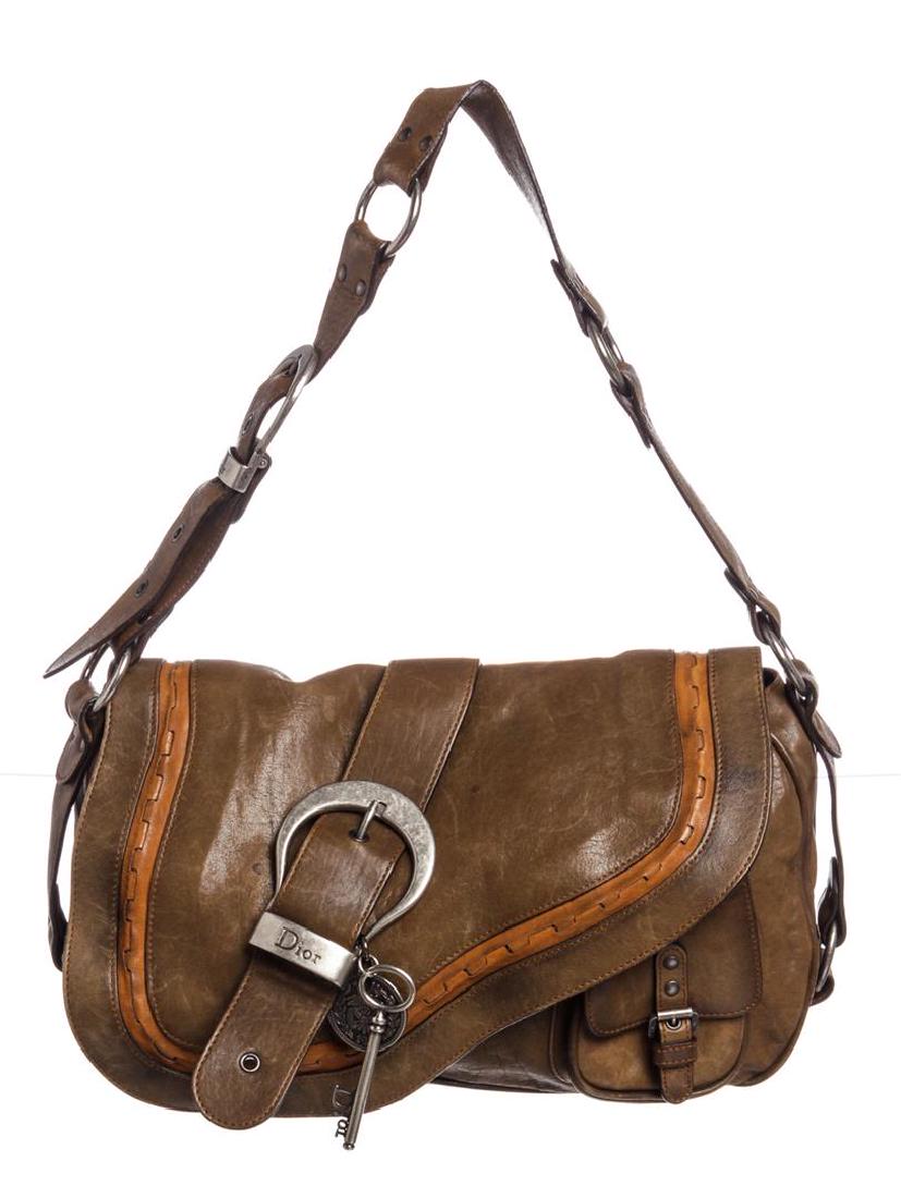 Christian Dior Olive Leather Gaucho Saddle Bag: Olive brown leather Christian Dior Gaucho Saddle bag with antiqued silver-tone hardware, caramel leather trim, single flat shoulder strap, single exterior wall pocket at back, buckle embellishment wit