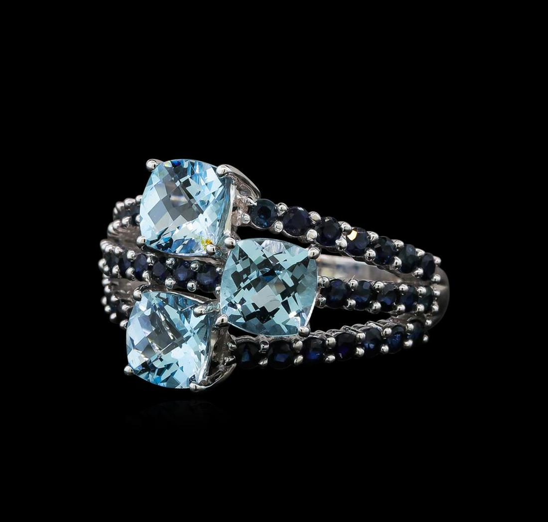 4.89 ctw Blue Topaz and Sapphire Ring - 14KT White Gold: One electronically tested 14KT white gold ladies cast blue topaz and sapphire ring with a bright polish finish. The ring features a series of three stacked blue topaz and sapphire ribbons, completed b
